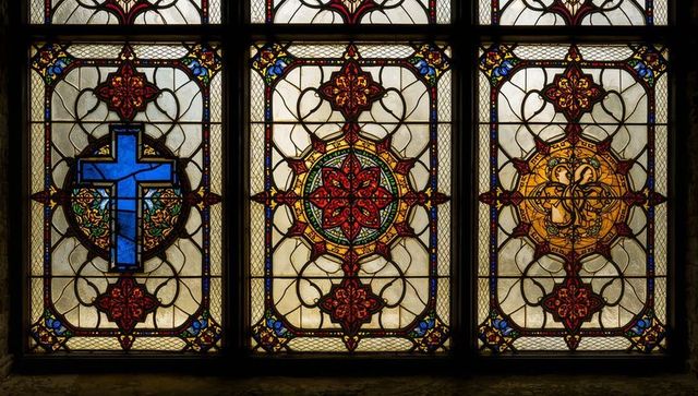 Intricate stained glass panels with religious themes in church interior