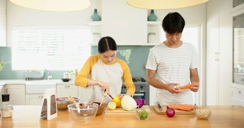 Young Couple Preparing Healthy Salad in Modern Home Kitchen