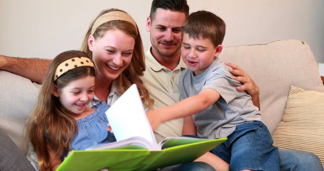 Happy Family of Four Enjoying Quality Time Reading Together - Download Free Stock Images Pikwizard.com