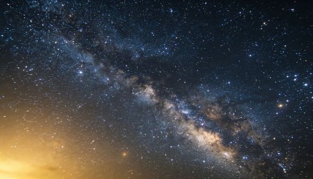 Milky way arcing across remote night sky, bright galactic core, nebula and dust lanes