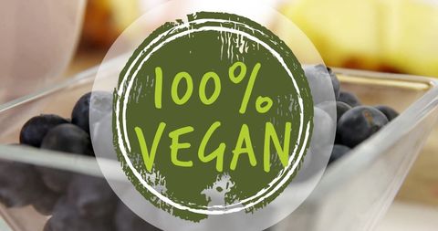 100% vegan label over fresh blueberries on table