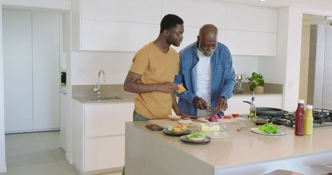 Father and Son Preparing Meal Together in Modern Kitchen