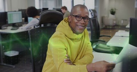 Professional in Yellow Hoodie Working in Modern Office with Digital Overlay