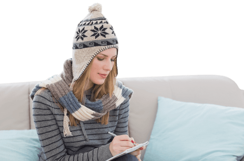 Caucasian Woman in Winter Attire Writing on Couch with Transparent Background