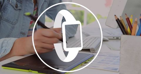 Graphic designer using tablet with smartwatch icon overlay