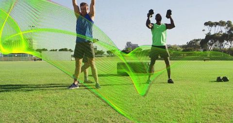 Outdoor group fitness training performing overhead dumbbell presses with tractor tire