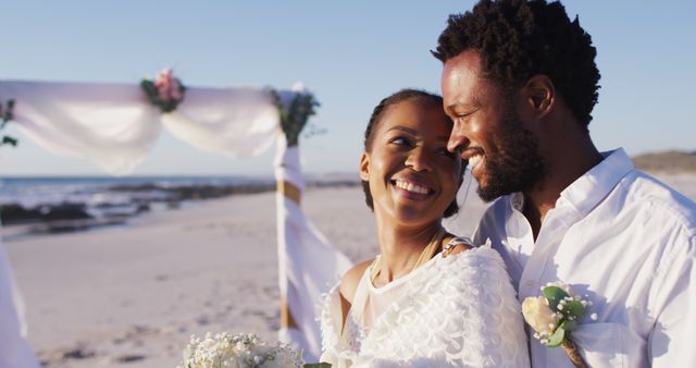 African american couple in love getting married and smiling on the beach. marriage, love and romance, holiday by the sea.