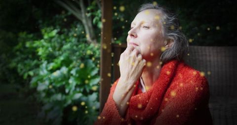 Thoughtful Mature Woman Relaxing in Tranquil Garden Atmosphere