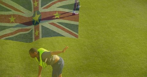 Soccer player stretching on field with flag overlay