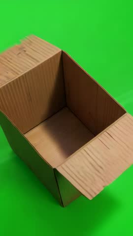 Panning camera circling empty cardboard box on green screen for vertical video compositing