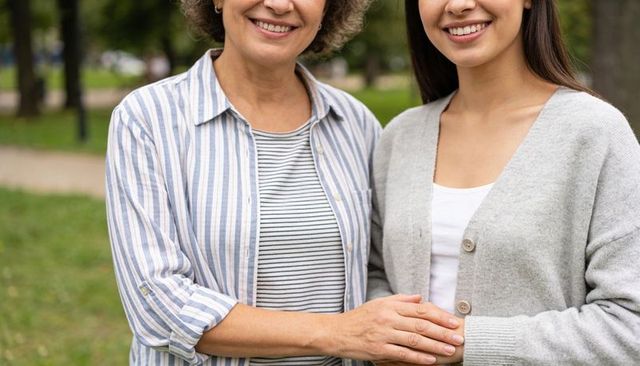 Smiling mother and daughter holding hands in park expressing warmth and family bond