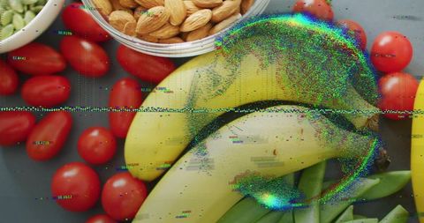 Top-down bananas, almonds and cherry tomatoes creating colorful digital glitch flatlay