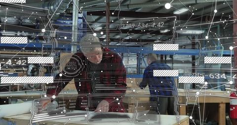 Carpenter inspecting workshop plans with AR overlay for precision woodworking