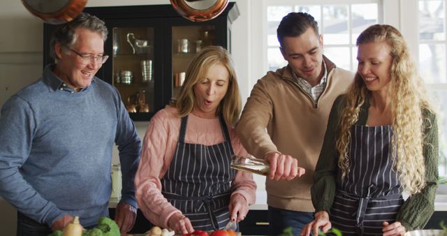 Image of happy caucasian senior mother and father cooking with adult daughter and husband in kitchen. Family, domestic life and togetherness concept digitally generated image.