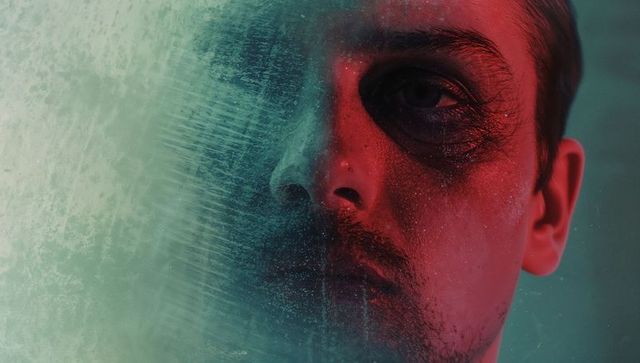 Dramatic Portrait of Man Through Frosted Glass with Eerie Lighting