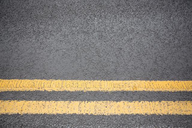 Yellow road marking on road surface, full frame