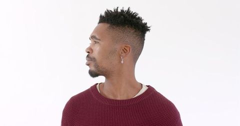 Young man in red sweater looking up thoughtfully isolated on white