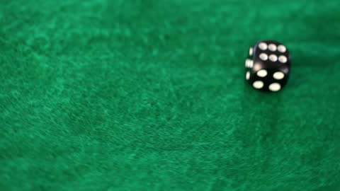 Motion Blur of Dice Rolling on Green Table Surface