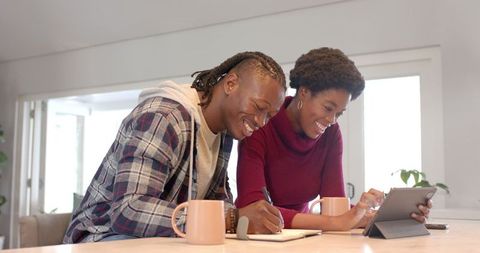 Happy Couple Planning Together on Tablet in Cozy Kitchen