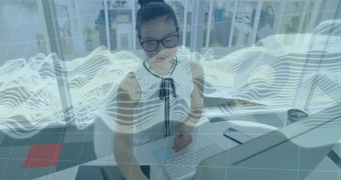 Businesswoman interacting with augmented reality data visualization at modern office desk