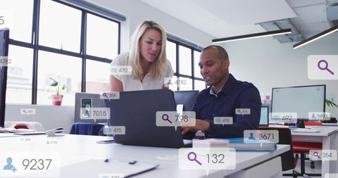 Business team collaborating over laptop with analytics overlays in modern office