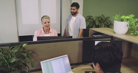 Diverse Coworkers Collaborate in Eco-Friendly Office Setting