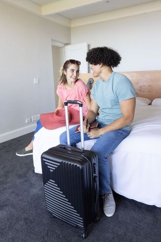 Young couple checking in with luggage and passports in modern hotel room weekend getaway