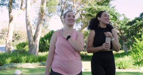 Diverse friends strolling in park with fitness gear