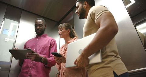 Diverse business team collaborating in elevator