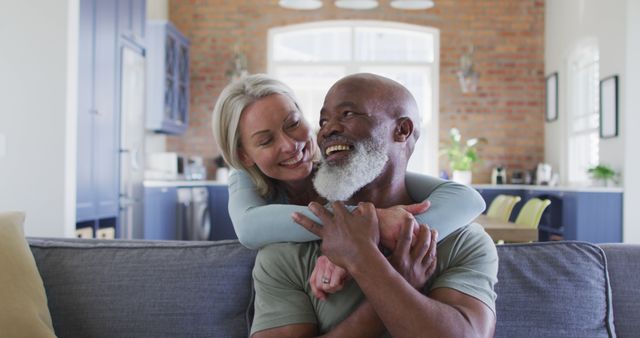 Portrait of biracial senior couple hugging each other and smiling at home. retirement senior couple lifestyle living concept