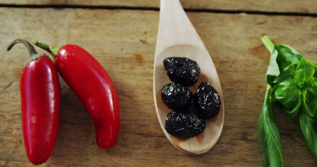 Fresh Red Chili Peppers, Black Olives, and Basil on Wooden Surface - Download Free Stock Images Pikwizard.com