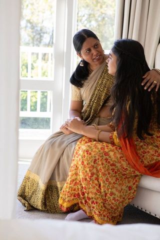Indian mother and daughter bonding in traditional dress at home