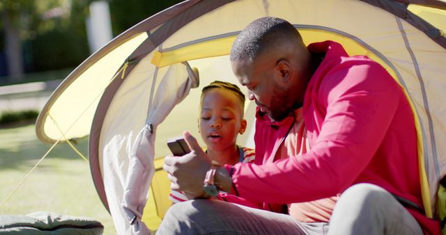 Father and Son Sitting Inside a Tent Using a Smartphone - Download Free Stock Images Pikwizard.com