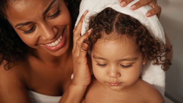 Mother drying toddler with towel during bath time, intimate bonding and gentle care