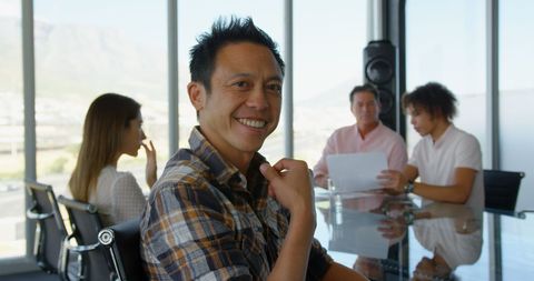 Confident businessman smiling amid productive office meeting