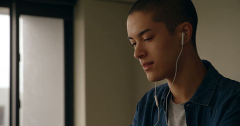 Young Man Listening to Music at Home with Earbuds - Download Free Stock Images Pikwizard.com