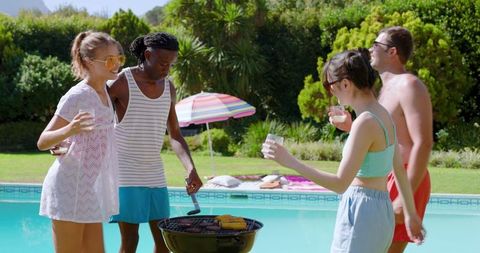 Diverse friends enjoying poolside barbecue gathering