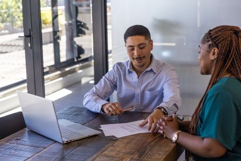 Advisor discussing documents with client in modern office setting