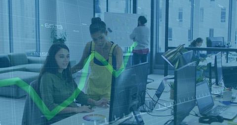 Women collaborating at desktop with green growth graph overlay showing business analytics