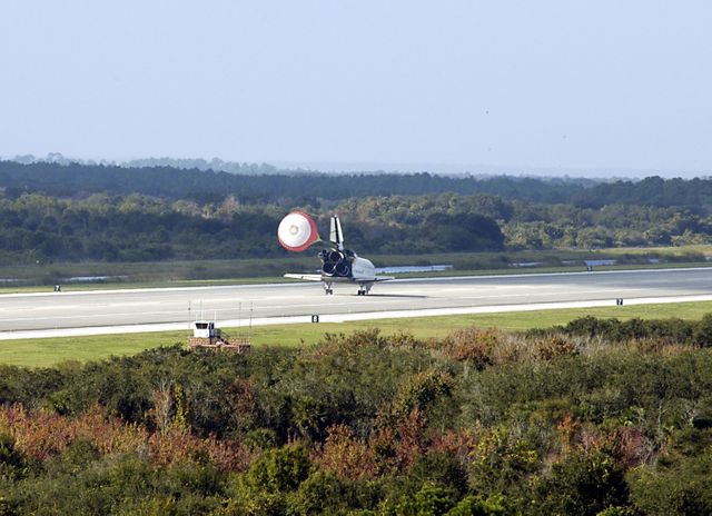 KENNEDY SPACE CENTER, FLA. - Space Shuttle Endeavour's drag chute deploys as the orbiter lands on runway 33 at the Shuttle Landing Facility after completing the 13-day, 18-hour, 48-minute, 5.74-million mile STS-113 mission to the International Space Station. Main gear touchdown was at 2:37:12 p.m. EST, nose gear touchdown was at 2:37:23 p.m., and wheel stop was at 2:38:25 p.m.  Poor weather conditions thwarted landing opportunities until a fourth day, the first time in Shuttle program history that a landing has been waved off for three consecutive days.  The vehicle carries the STS-113 crew, Commander James Wetherbee, Pilot Paul Lockhart and Mission Specialists Michael Lopez-Alegria and John Herrington, as well as the returning Expedition Five crew, Commander Valeri Korzun, ISS Science Officer Peggy Whitson and Flight Engineer Sergei Treschev. The installation of the P1 truss on the International Space Station was accomplished during the mission.