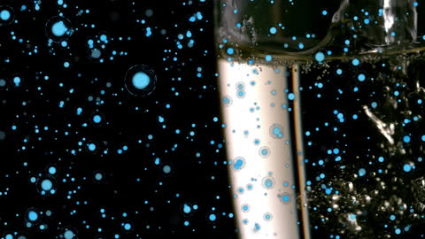 Champagne Pouring with Blue Circles Floating on Black Background