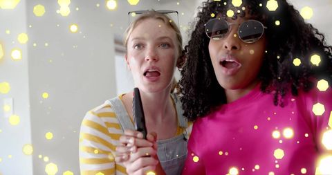 Teen girls singing with remote, sparkling lights adding excitement