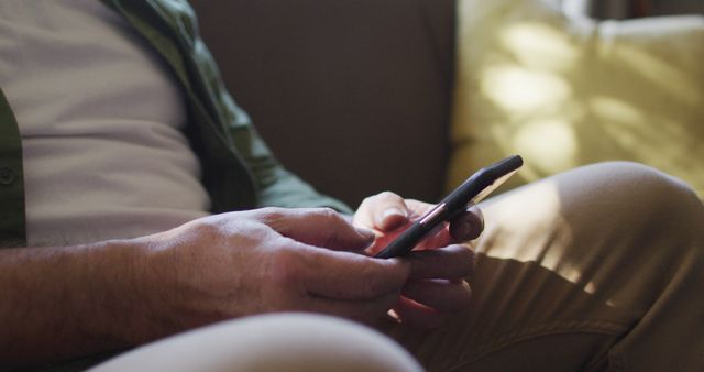 Man Using Mobile Phone on Couch in Casual Home Setting - Download Free Stock Images Pikwizard.com