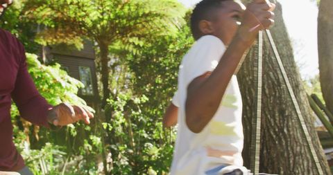 Family Fun in Garden: Father Pushing Son on Swing - Download Free Stock Images Pikwizard.com