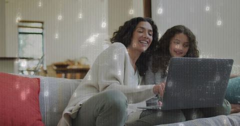 Mother guiding daughter on laptop with binary overlay, cozy home digital learning
