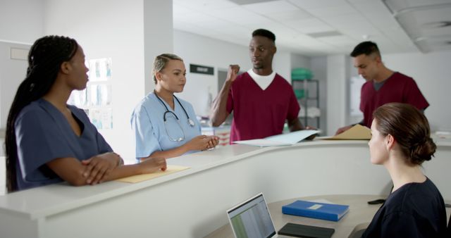 Diverse Medical Team Discussing Patient Records at Hospital Reception - Download Free Stock Images Pikwizard.com