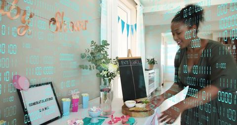 Pregnancy gender reveal host preparing dessert table with boy girl chalkboard pastel decor