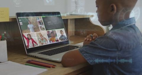 Child attending virtual classroom at home desk with laptop and headphones, studying online