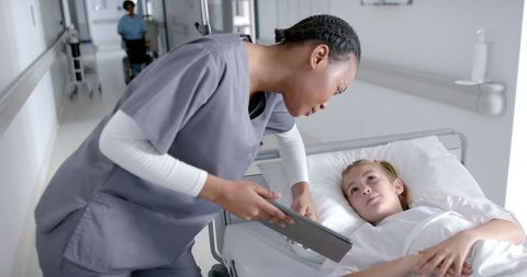 Caring Nurse Assists Young Patient in Hospital Ward