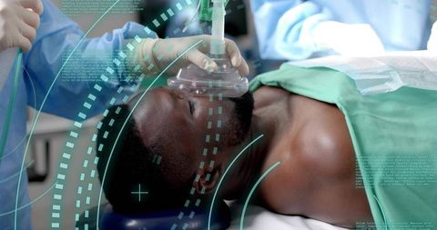 Surgical Team Ventilating Patient with Anesthesia Mask in Hospital